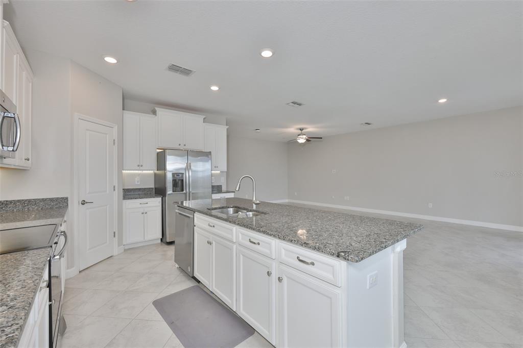 11454 Freshwater Ridge Drive Riverview, FL 33569 - Photo 11 of 65 a kitchen with stainless steel appliances granite countertop a sink stove and refrigerator