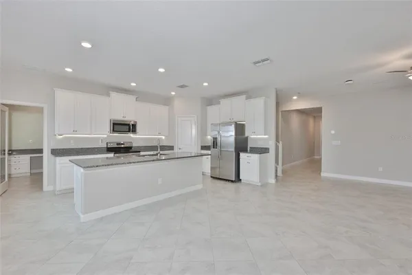 a kitchen with stainless steel appliances granite countertop a stove a sink and a refrigerator