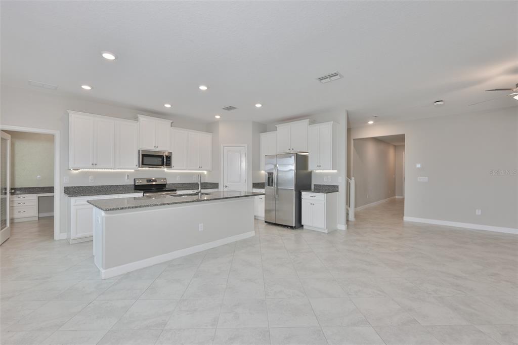 11454 Freshwater Ridge Drive Riverview, FL 33569 - Photo 14 of 65 a kitchen with stainless steel appliances kitchen island sink refrigerator and stove