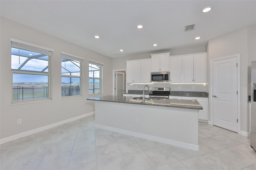 11454 Freshwater Ridge Drive Riverview, FL 33569 - Photo 16 of 65 a kitchen with stainless steel appliances granite countertop a stove a sink and a refrigerator