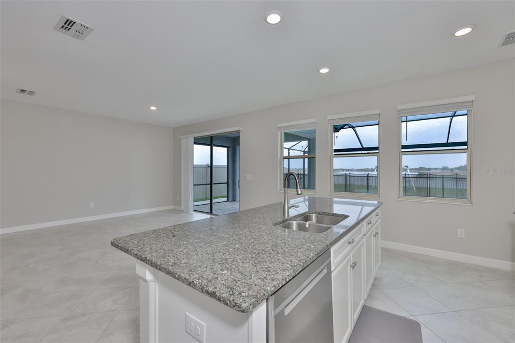 11454 Freshwater Ridge Drive Riverview, FL 33569 - Photo 17 of 65 a kitchen with granite countertop kitchen island a sink appliances and a counter top space