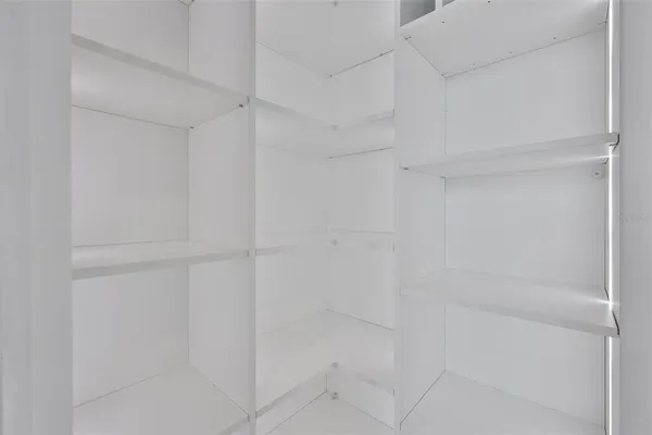 a view of a small space with a chandelier fan