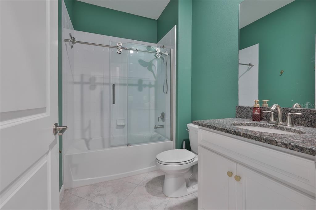 11454 Freshwater Ridge Drive Riverview, FL 33569 - Photo 21 of 65 a bathroom with a granite countertop sink toilet and shower