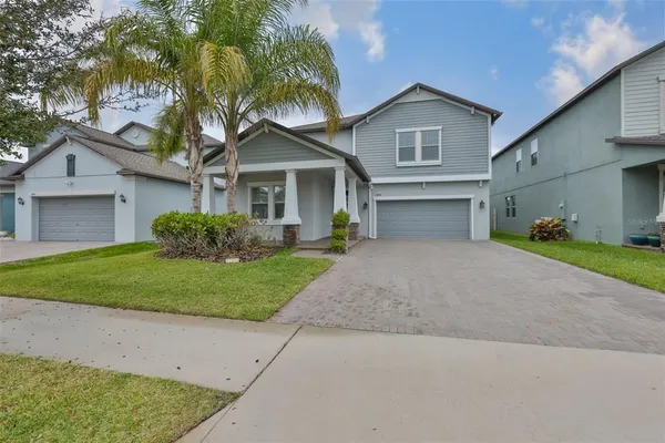 a front view of a house with a garden and trees