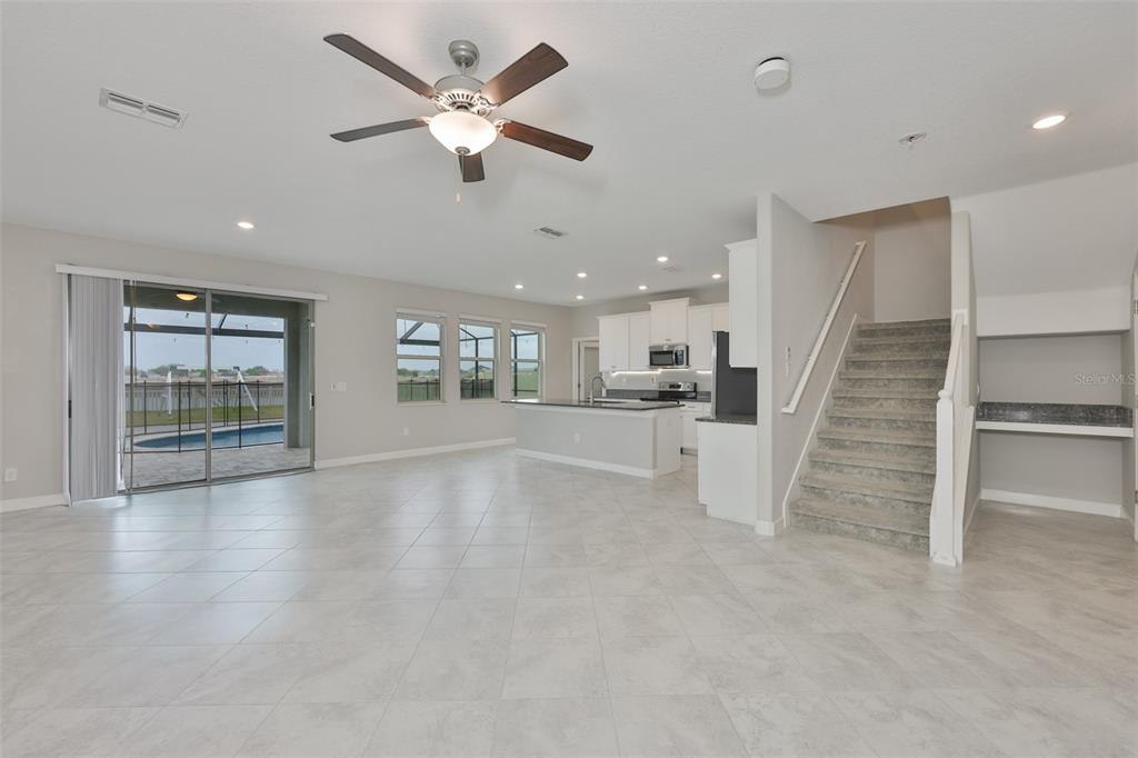 11454 Freshwater Ridge Drive Riverview, FL 33569 - Photo 9 of 65 an empty space with wooden floor a ceiling fan and windows