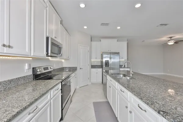a large kitchen with stainless steel appliances granite countertop a lot of counter space