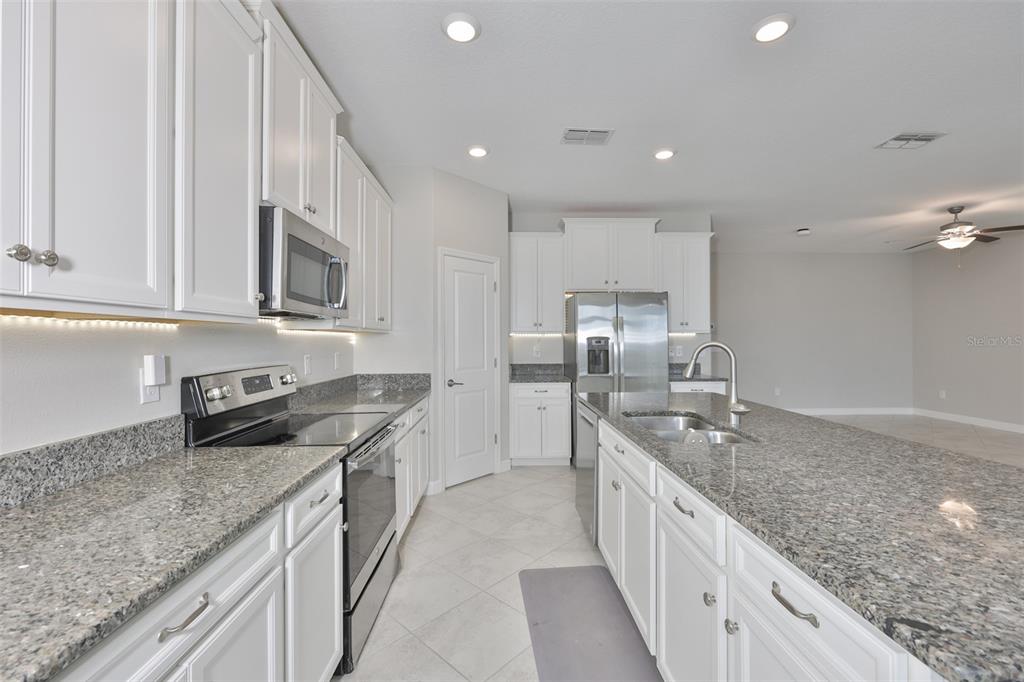 11454 Freshwater Ridge Drive Riverview, FL 33569 - Photo 10 of 65 a large kitchen with stainless steel appliances granite countertop a lot of counter space