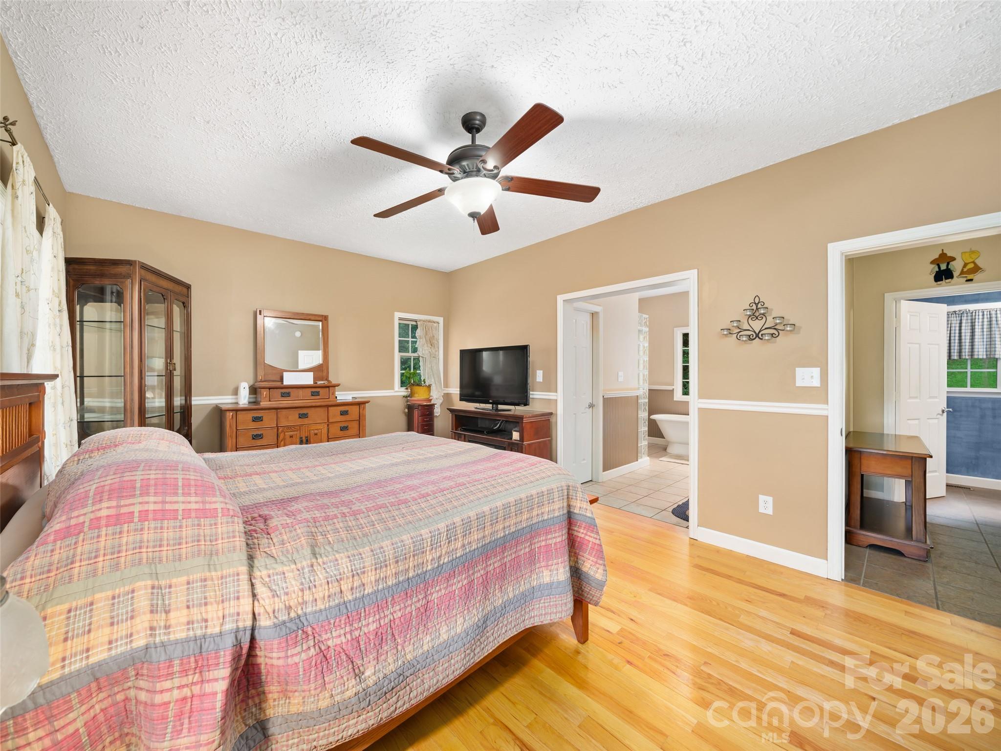 2216 Beans Creek Road Bakersville, NC 28705 - Photo 14 of 39 a bedroom with a large bed a chandelier and dresser