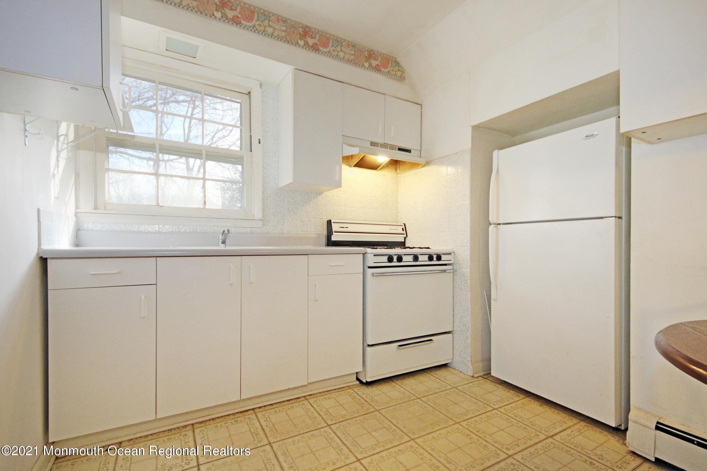 700 Hopping Road Belford, NJ 07718 - Photo 29 of 35 a kitchen with white cabinets and white appliances