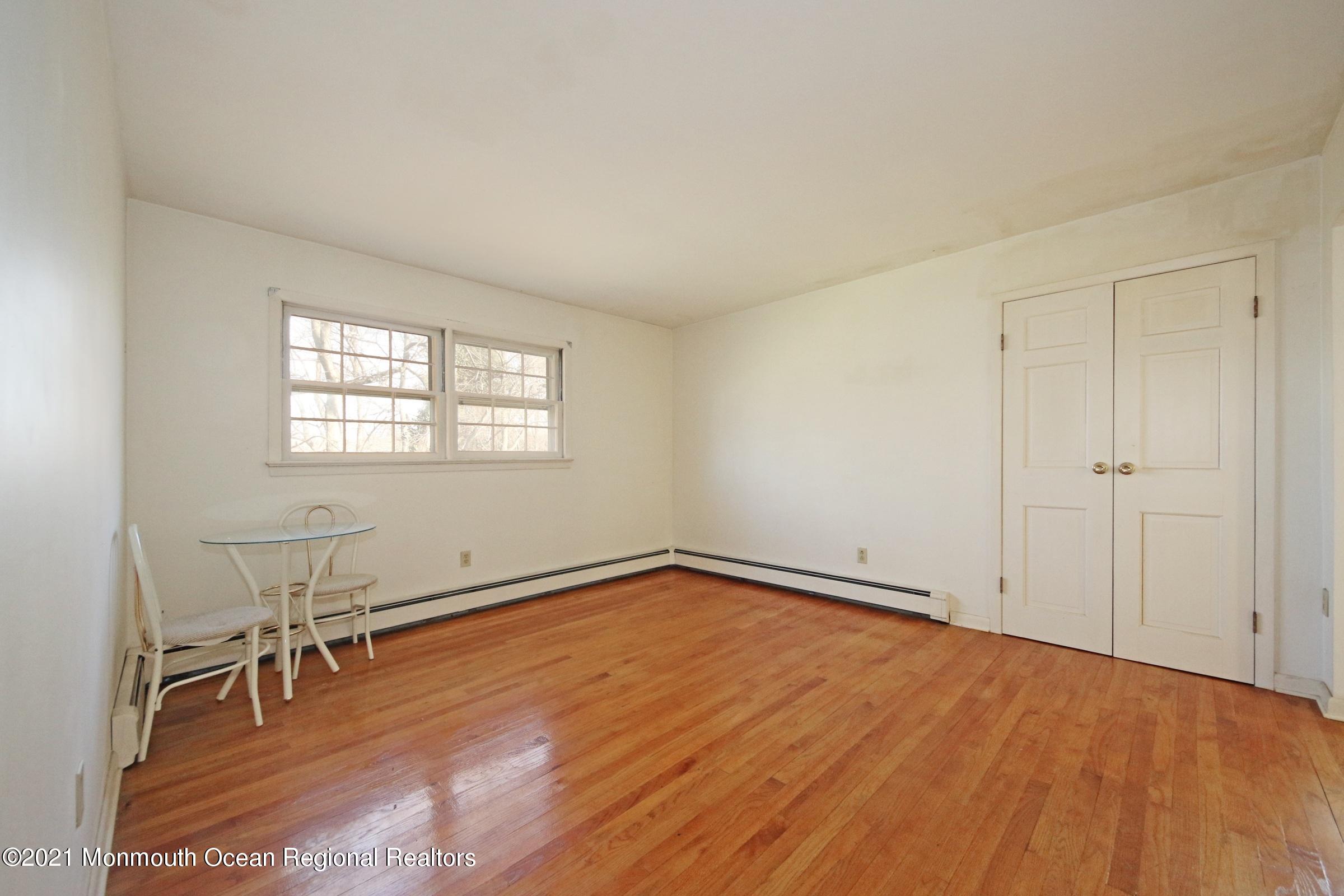 700 Hopping Road Belford, NJ 07718 - Photo 32 of 35 an empty room with wooden floor and windows
