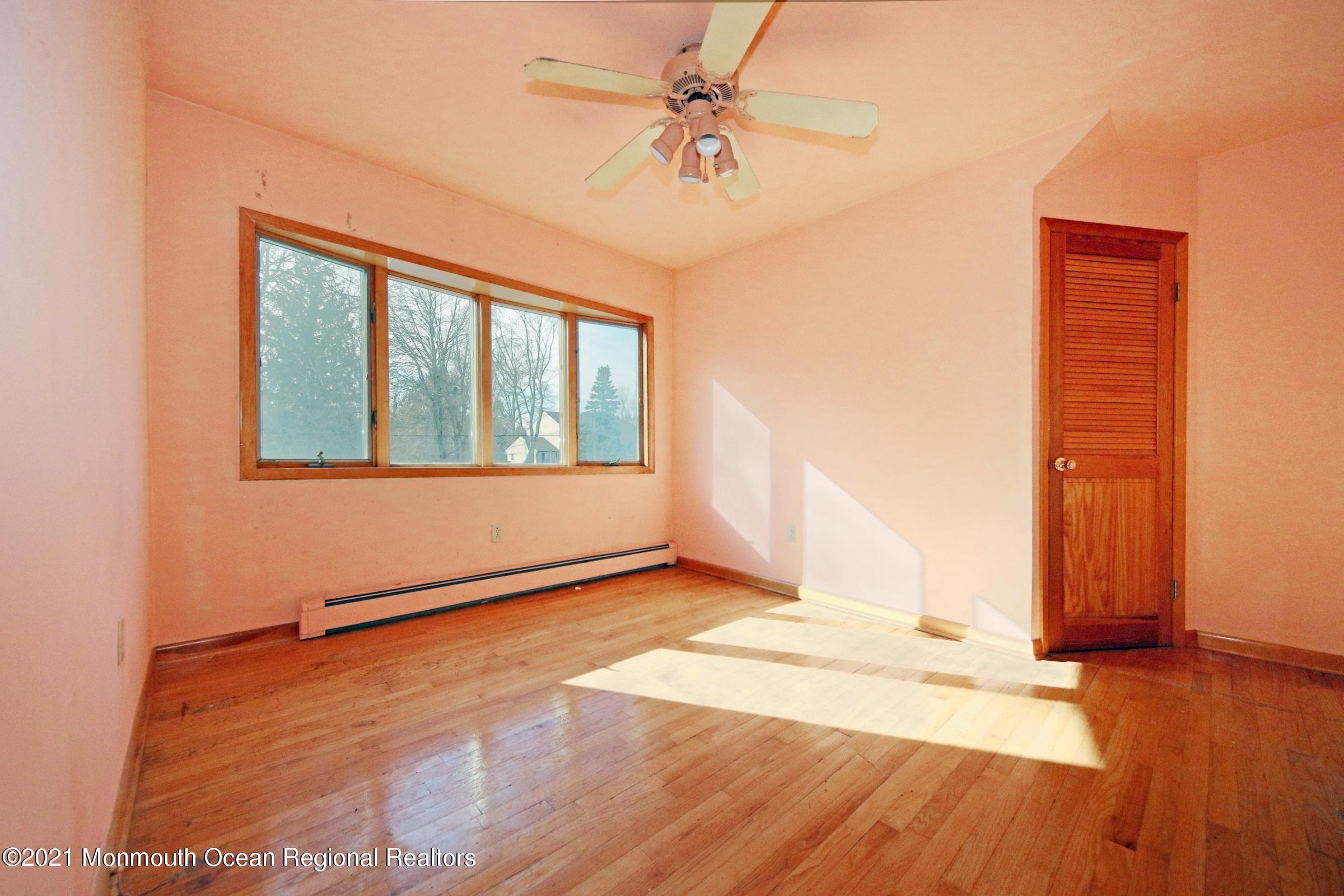 700 Hopping Road Belford, NJ 07718 - Photo 34 of 35 an empty room with wooden floor and windows