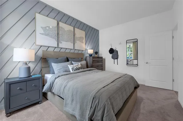 a bedroom with a bed and a lamp on dresser