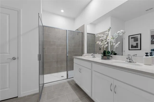 a bathroom with a double vanity sink mirror and shower