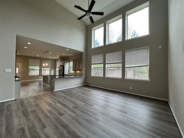 a view of an empty room with window and wooden floor