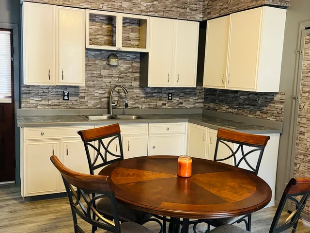 a view of a kitchen with kitchen island a dining table and chairs