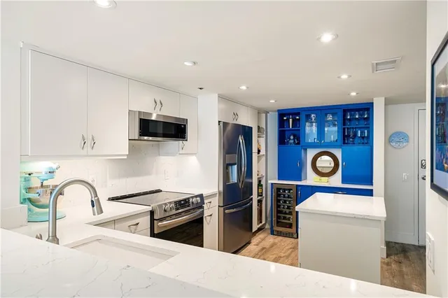 a kitchen with stainless steel appliances granite countertop a refrigerator sink and stove
