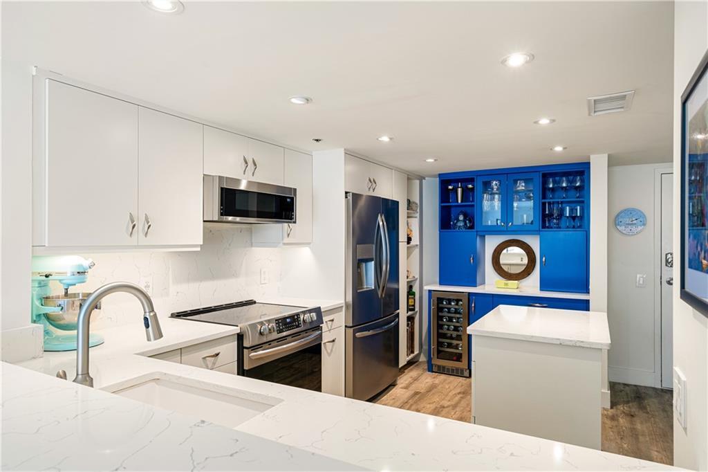 a kitchen with stainless steel appliances granite countertop a refrigerator sink and stove