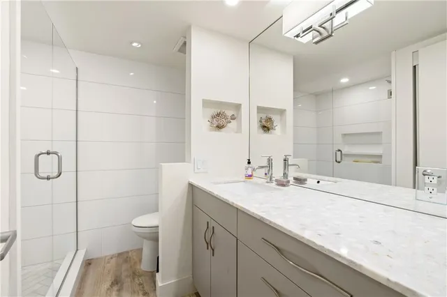 a bathroom with a granite countertop sink a toilet and shower