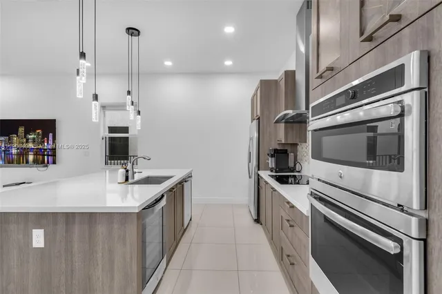 a kitchen with stainless steel appliances a sink and a refrigerator
