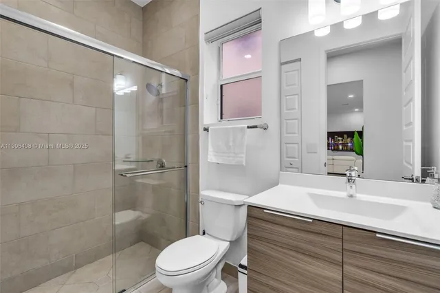 a bathroom with a sink a toilet and shower