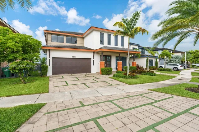 a front view of a house with a yard and potted plants
