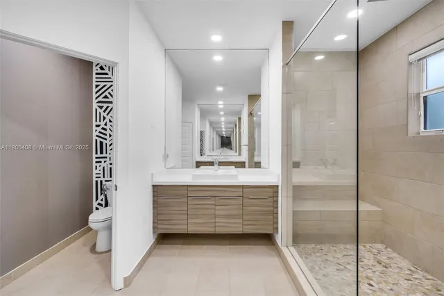 a white bed sitting in a room next to a lamp