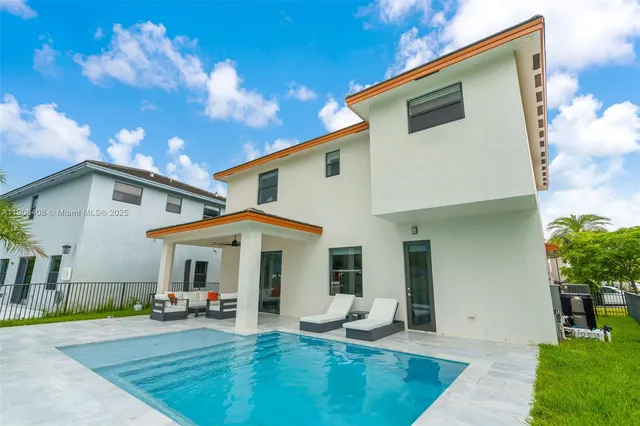 a view of a white house with swimming pool in front of it