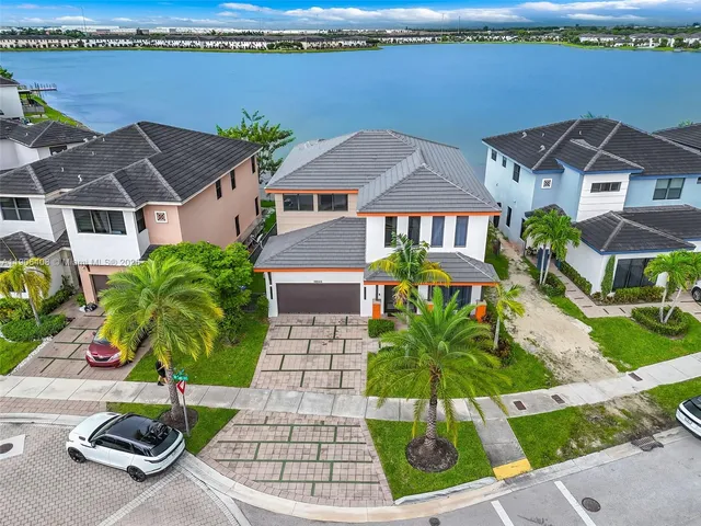 an aerial view of residential houses with outdoor space and parking