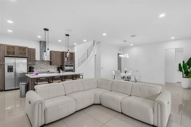 a living room with furniture and a view of kitchen
