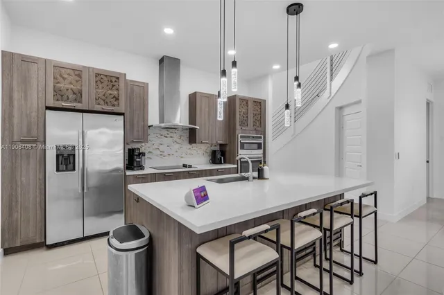 a kitchen with stainless steel appliances granite countertop a sink refrigerator and microwave