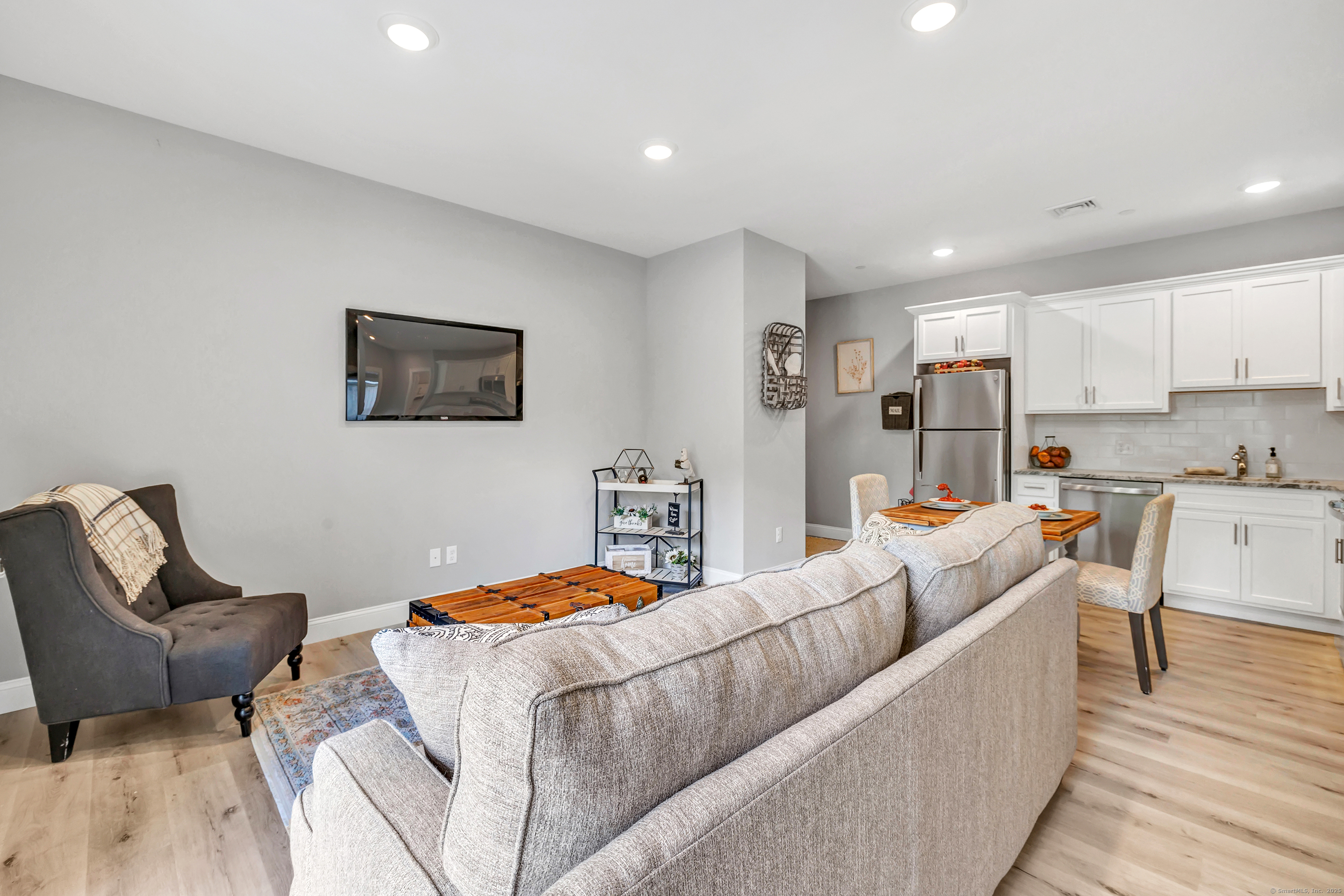 303 Bridgeport Avenue, Unit 205 Shelton, CT 06484 - Photo 11 of 36 a living room with furniture and a wooden floor