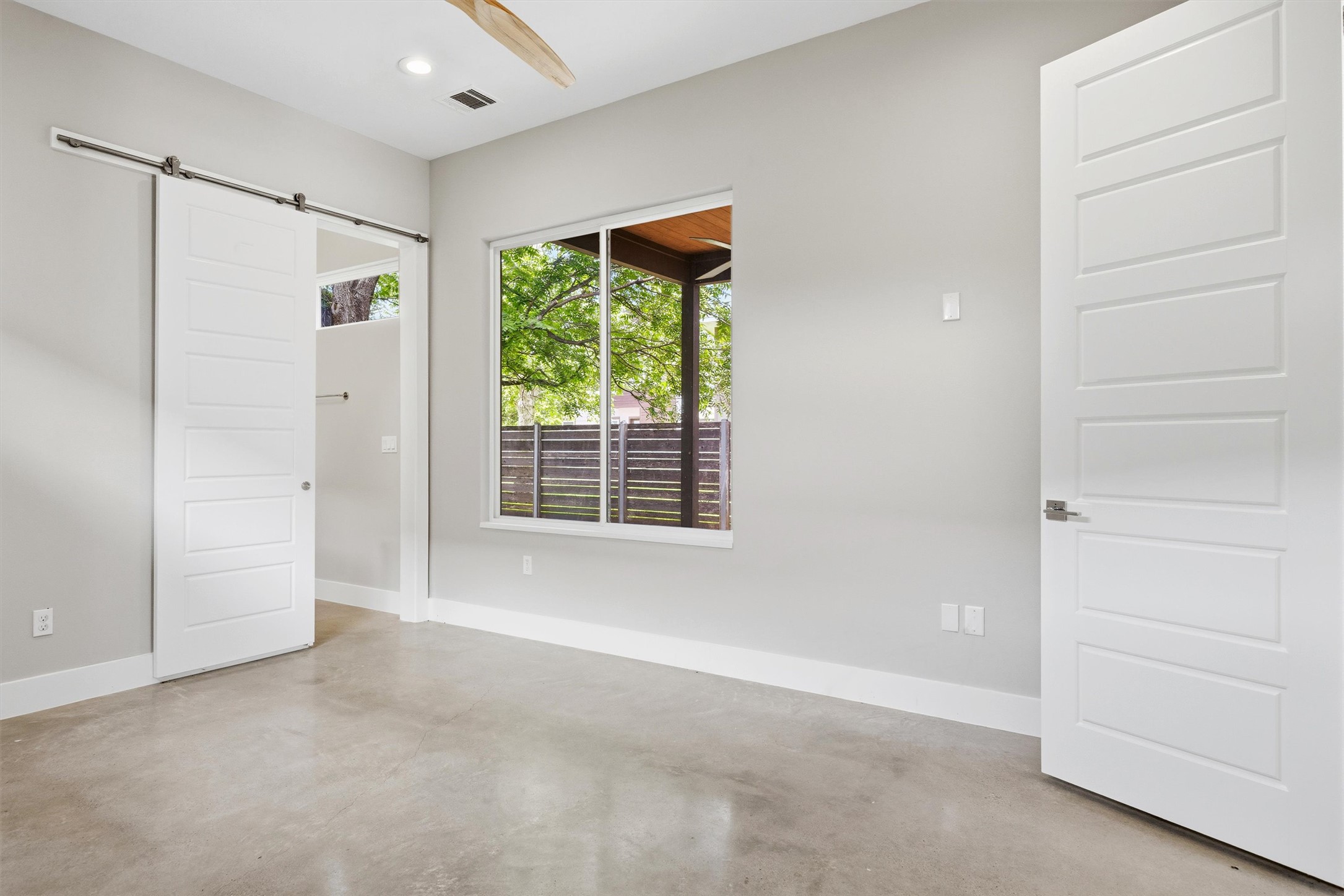 1210 Stobaugh Street, Unit B Austin, TX 78757 - Photo 18 of 40 Natural illumination fills this room, complemented by concrete floors and sleek white trim.