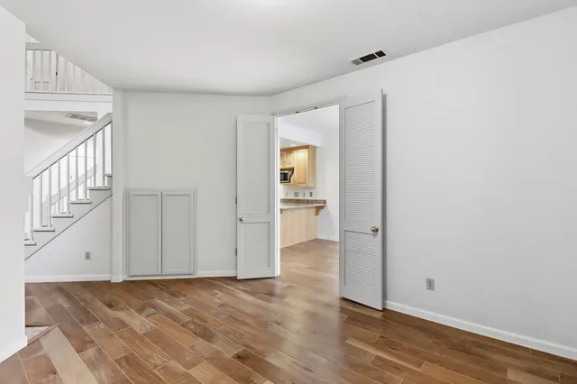 a view of a hallway with wooden floor and staircase