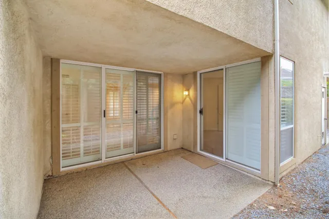 an empty room with large windows and stairs