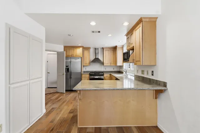 a kitchen with stainless steel appliances granite countertop a refrigerator and a stove top oven