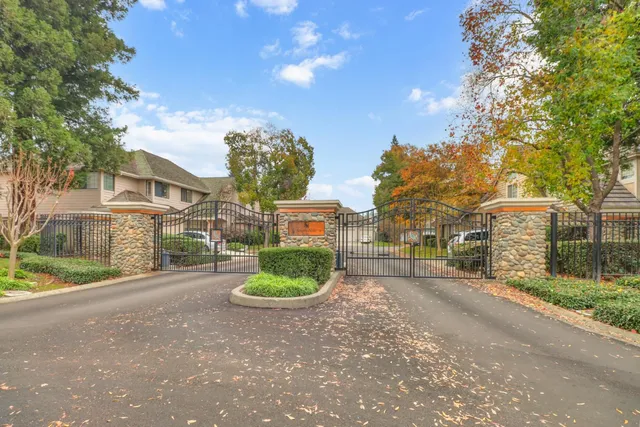 a view of a house with a yard and large trees