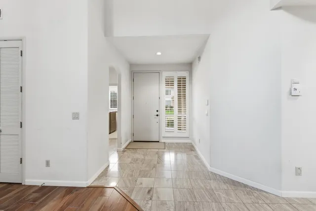 a view of an empty room with wooden floor fireplace and a window