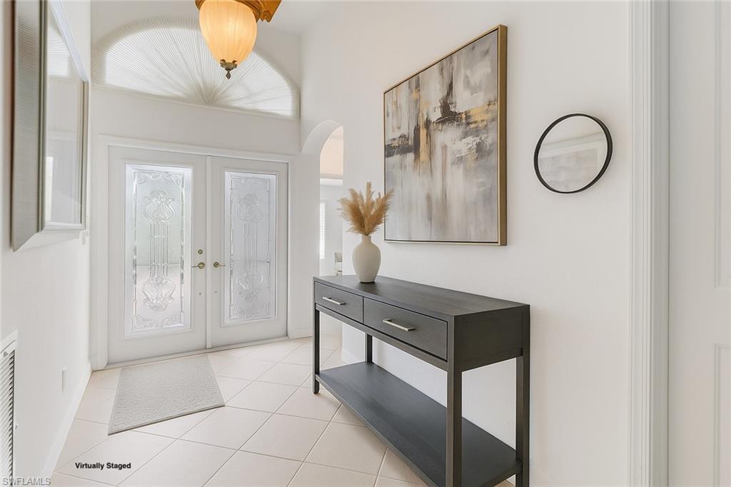 2089 Isla De Palma Circle Naples, FL 34119 - Photo 8 of 19 Entryway featuring light tile patterned flooring, french doors, and arched walkways
