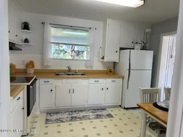 a kitchen with granite countertop a refrigerator and a sink