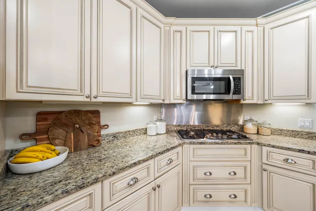 a kitchen with granite countertop a refrigerator and a sink
