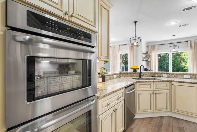 a kitchen with stainless steel appliances granite countertop a sink a counter space and a chandelier