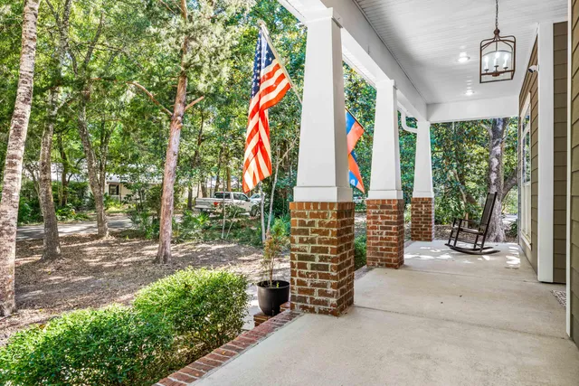 a view of a hallway with wooden floor and a chandelier