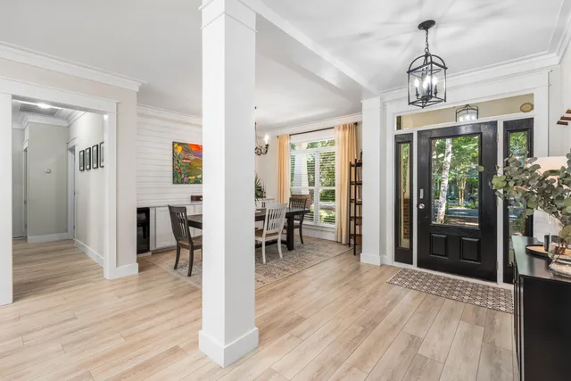 a view of a dining room with furniture a chandelier and wooden floor