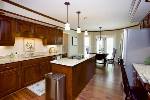 a kitchen with stainless steel appliances granite countertop wooden floors sink stove and cabinets