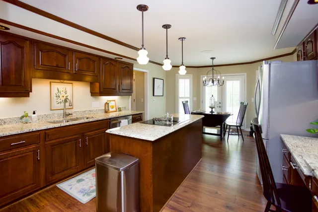a kitchen with stainless steel appliances granite countertop wooden floors sink stove and cabinets