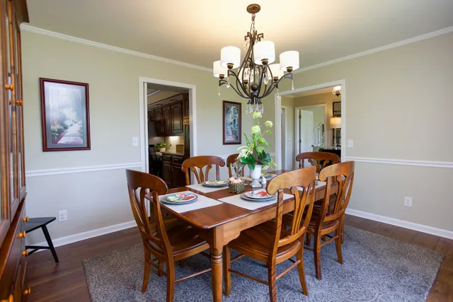 a view of a dining room with furniture a chandelier and wooden floor