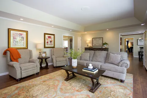 a living room with furniture a rug and a table