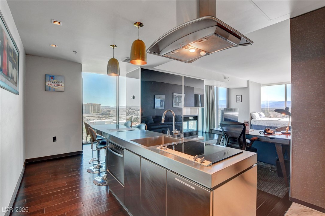 4381 West Flamingo Road, Unit 1121 Las Vegas, NV 89103 - Photo 33 of 33 Kitchen featuring a sink, black electric stovetop, open floor plan, dark wood-type flooring, and island exhaust hood