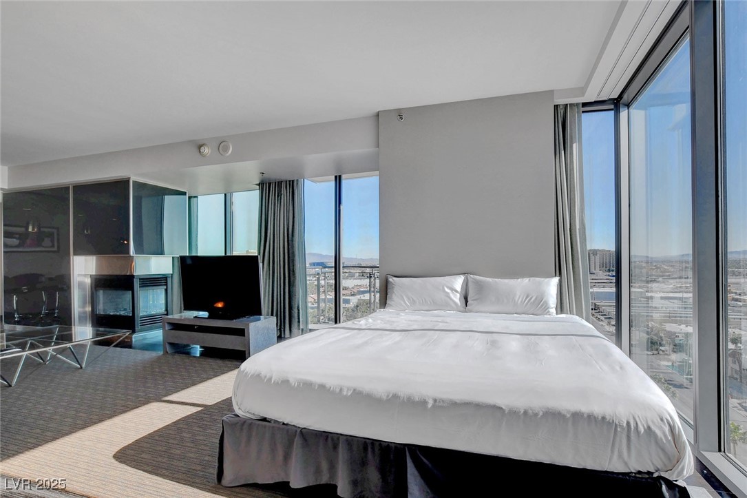 4381 West Flamingo Road, Unit 1121 Las Vegas, NV 89103 - Photo 11 of 33 Bedroom featuring a fireplace