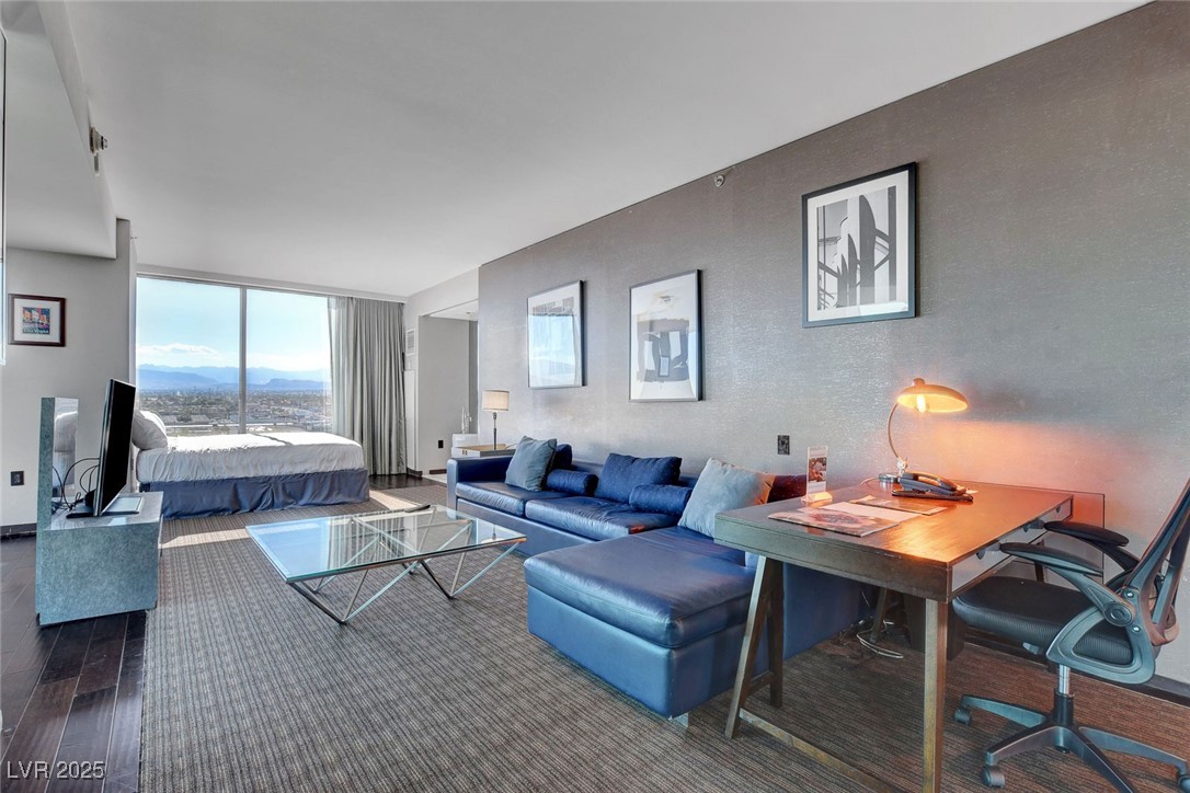 4381 West Flamingo Road, Unit 1121 Las Vegas, NV 89103 - Photo 8 of 33 Living area featuring wood finished floors and expansive windows